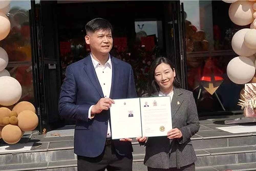 Two guests holding an official certificate